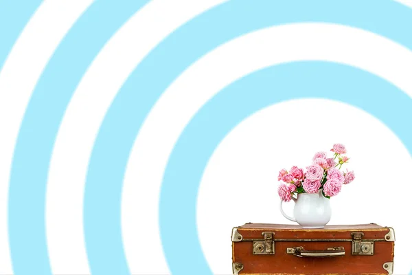 Розовые цветы в кувшине на старый коричневый винтажный чемодан . — стоковое фото