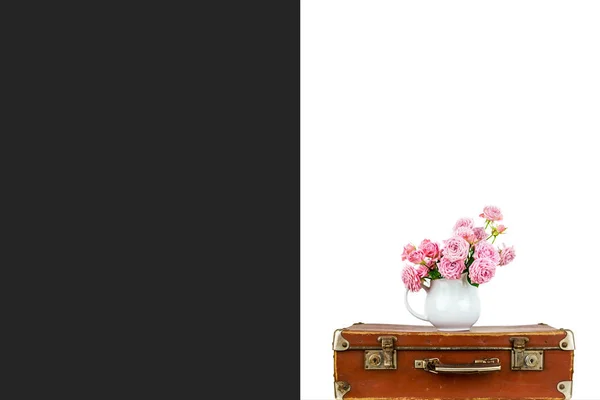 Rosa blommor i kannan på gammal brun vintage resväska. Rosor i kannan. Rosa rosor. Shabby chic. — Stockfoto