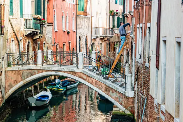 Utcai élet Velencében. Az ember festi a falat Velencében, Olaszországban — Stock Fotó