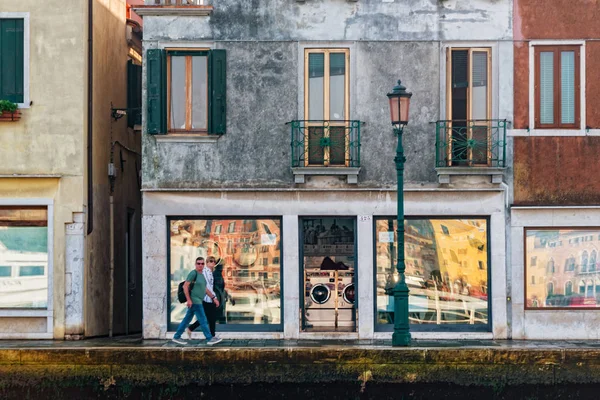Уличная жизнь Венеции. Люди ходят по фасаду здания рядом с набережной лагуны на острове Джудекка . — стоковое фото