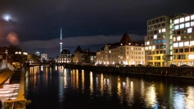Berlin Şehri 4K zaman aşımı. Geceleri Berlin 'in merkezinde ünlü TV kulesi ve Spree nehri olan Müze Adası manzarası.