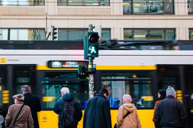 Berlin, Germany - December, 2019: Street life in Berlin. Pedestrians on blurred tram background.