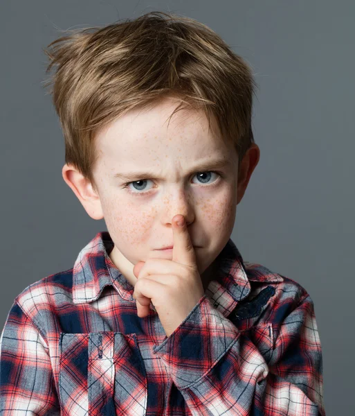 Нещасний молодий хлопчик з пальцем на губах для секретного жесту — стокове фото