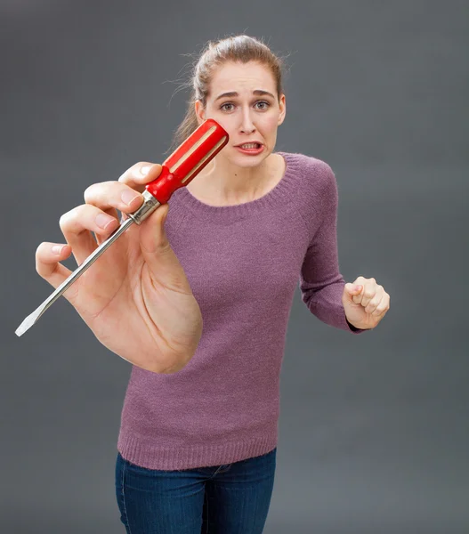 Imbarazzo giovane donna mostrando cacciavite per l'ansia fai da te e lo stress — Foto Stock