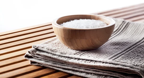 Sal de banho mineral em copo de madeira definido na toalha de algodão — Fotografia de Stock