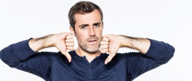 young man having regrets,expressing disappointment,sadness with thumbs down