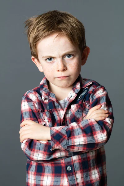 Niño joven en conflicto con el pelo rojo desordenado cruzando sus brazos — Foto de Stock
