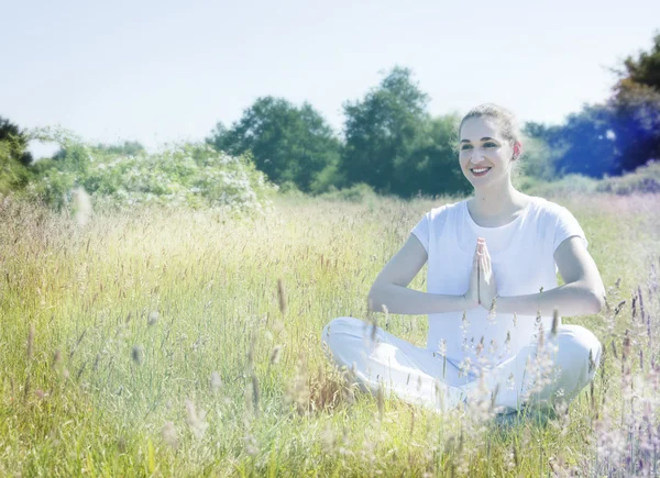 Smiling beautiful yoga girl relaxing on grass for romantic happiness — Stock fotografie