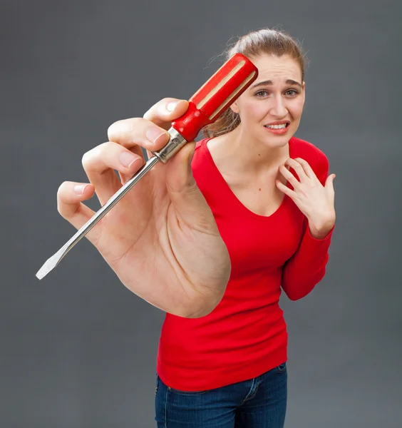 Mujer joven hermosa asustada con destornillador simbólico para el miedo DIY — Foto de Stock