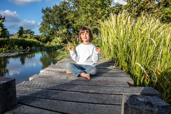 Дзен ребенок делает йогу закрыв глаза для расслабления и памятования — стоковое фото