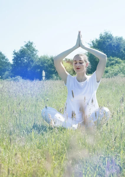 Yoga χαλαρή κορίτσι, τα μάτια κλειστά, προσεύχεται σταυρωμένα πόδια στο γρασίδι — Φωτογραφία Αρχείου