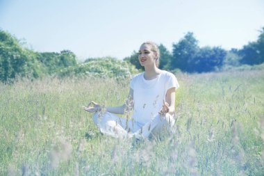 gülümseyen güzel yoga-kız açıklık yeşil çevrede için meditasyon