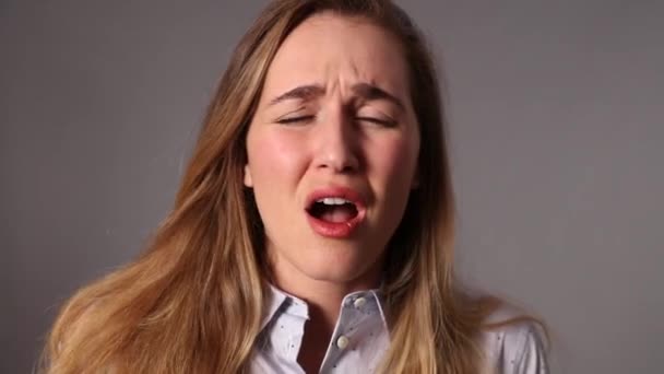 Больная молодая женщина чихает, сморкаясь салфеткой — стоковое видео