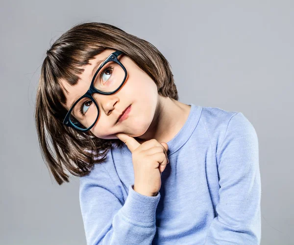 Thoughtful beautiful little girl with intelligent eyeglasses to imagine — Stock Photo, Image