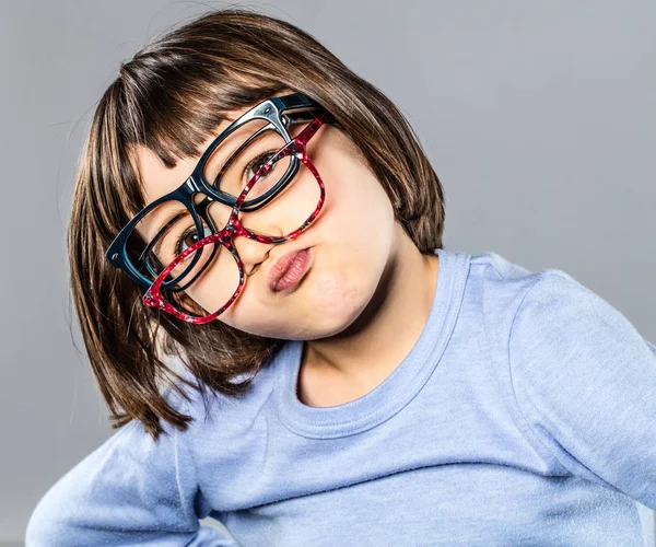 Niño pequeño juguetón probando varias gafas de vista haciendo pucheros y dudando — Foto de Stock