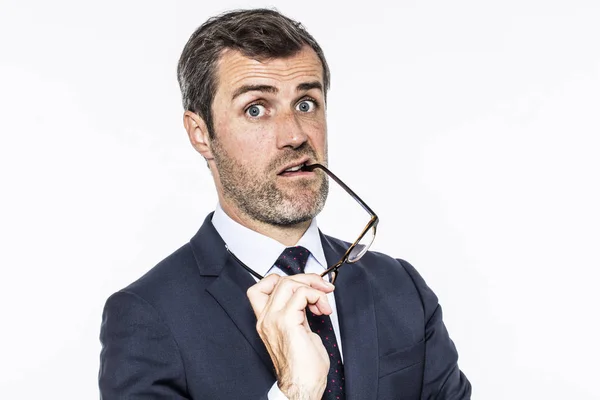 Amazed bearded middle aged businessman biting his eyeglasses for interrogation — Stock Photo, Image