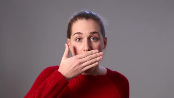 Beautiful young woman covering her mouth for reaction to mistake — Stock Video