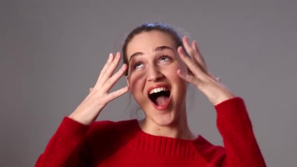 Красива молода жінка сміється, прикриваючи своє вражаюче обличчя — стокове відео