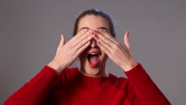 Humorné mladá žena hraje na schovávanou zakryla tvář — Stock video