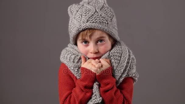 Infeliz niño pequeño protegiendo del frío con ropa de invierno caliente — Vídeos de Stock