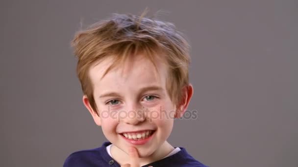 Expressive little child smiling, cuddling himself, shrugging shoulders for no — Stock Video