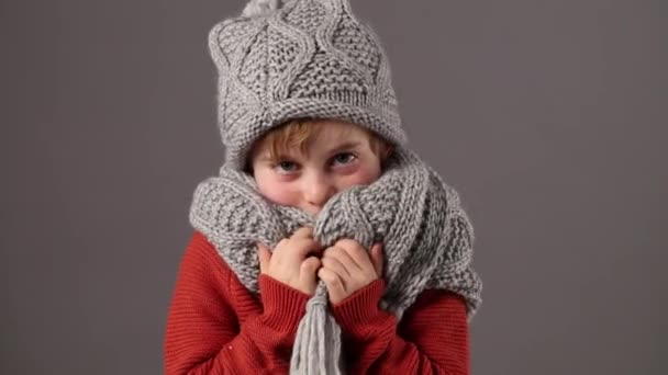 Feliz niño de invierno tocando su ropa de lana para calentar — Vídeos de Stock