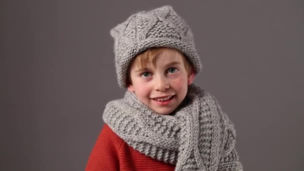 Smiling boy with freckles wearing wool winter hat and scarf — Stock Video