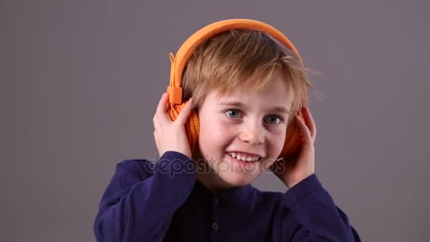 Niño adorable feliz con auriculares escuchando música fresca — Vídeo de stock