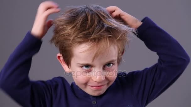 Criança pequena bonito com cabelo vermelho coçando a cabeça, dentro de casa — Vídeo de Stock