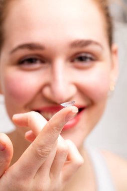 bir kontakt lens bulanık gülümseyen güzel bir kız tarafından gösterilen