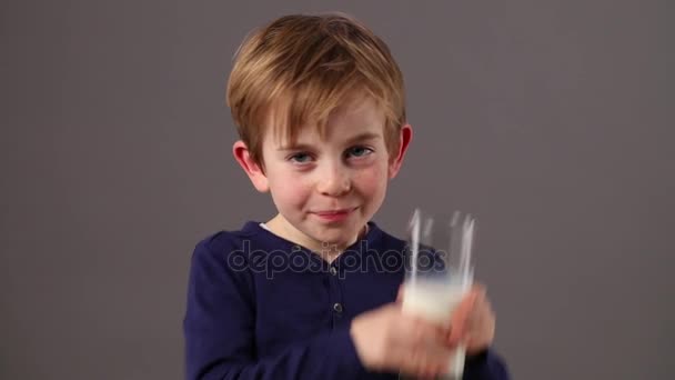 Beautiful young boy holding glass of organic milk for health — Stock Video