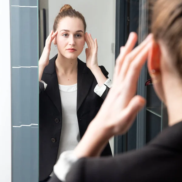 Feliz hermosa joven mujer de negocios comprobando su maquillaje en la mañana — Foto de Stock