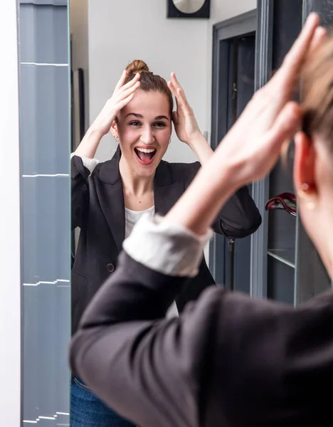Extrovertida joven hermosa mujer de negocios disfrutando mirando el espejo de casa — Foto de Stock