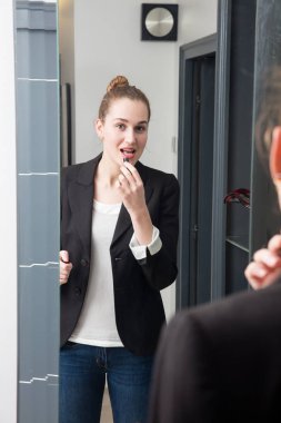 ruj ayakta ayna önünde olan güzel kadın