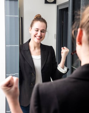 aynada kaldırdı başarılı silah ile gülümseyen dinamik genç kadın