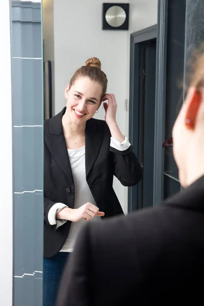 Feliz hermosa joven con ropa inteligente comprobar su peinado — Foto de Stock