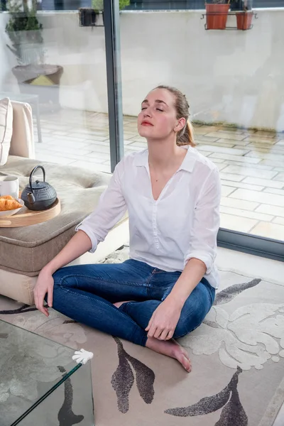 Расслабленная молодая женщина откидывается на утреннюю йогу и медитацию — стоковое фото