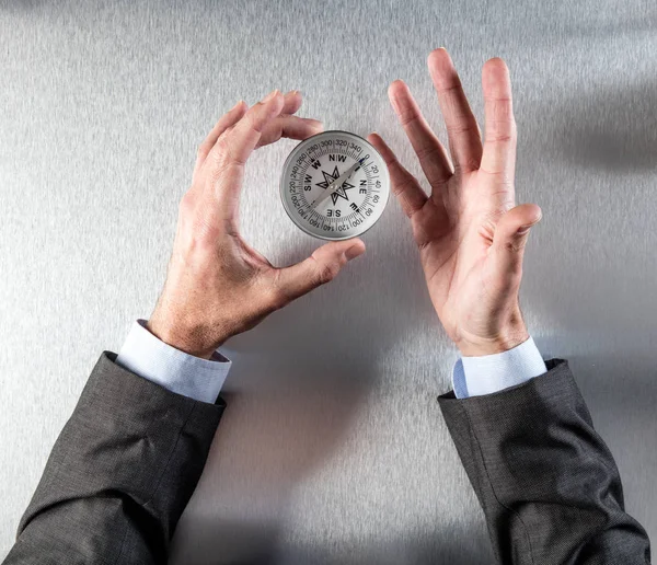 Руки бізнесмена тримають компас, шукаючи стратегію управління — стокове фото
