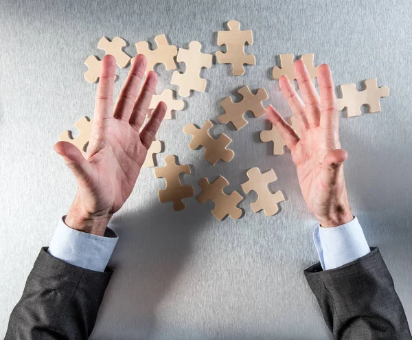 expressive businessman hands challenging the connection of jigsaw pieces