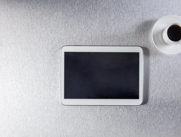 Pantalla blanca en tableta digital y café en escritorio metálico — Foto de Stock