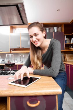 gülümseyen güzel genç kadın şarap ile bir dijital ekran dokunaklı