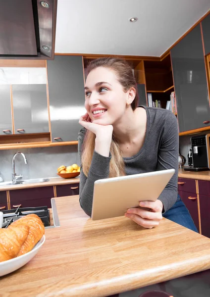 Gorgeous woman holding tablet on a kitchen counter for imagination — Stock Photo, Image