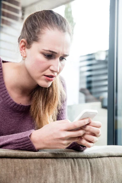suspicious beautiful young woman frowning in reading her text messages