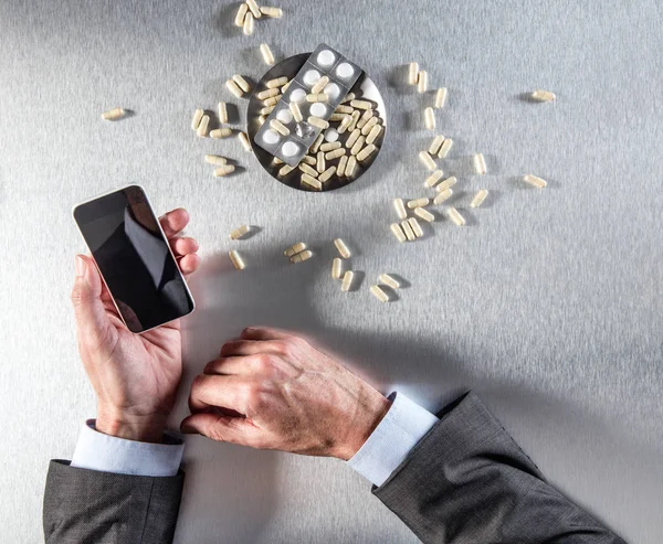 Manos de hombre de negocios sosteniendo el teléfono inteligente para ordenar medicamentos o drogas en línea — Foto de Stock
