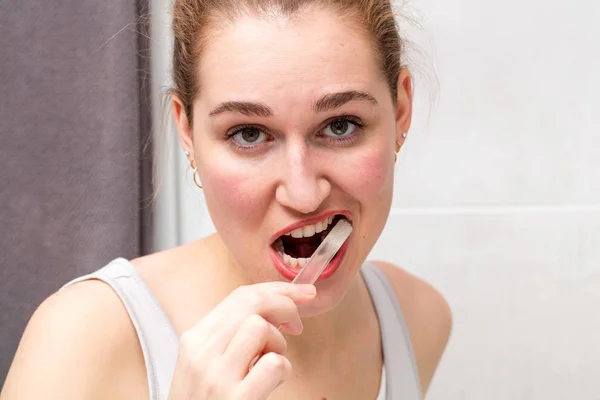 聚焦美丽的年轻女子，她刷牙小心 — 图库照片