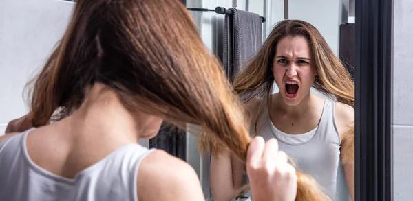 Mujer joven en crisis gritando delante de su espejo —  Fotos de Stock