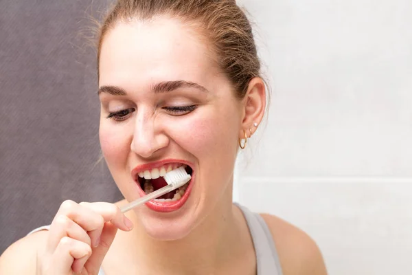Счастливая молодая женщина открывает рот, чтобы почистить зубы — стоковое фото