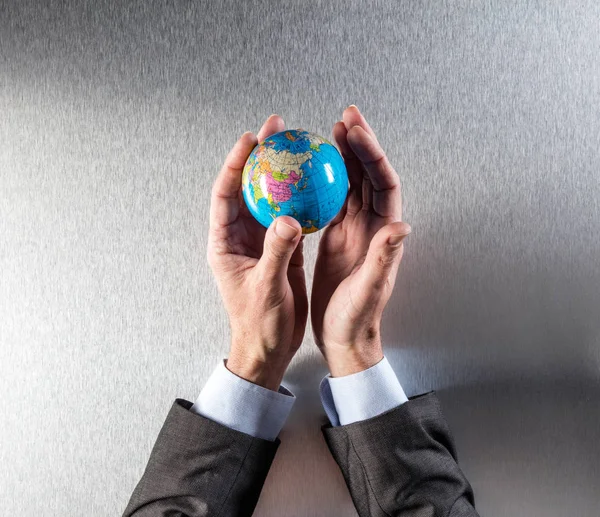 green businessman holding the earth within hands for human responsibility