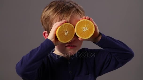 Niño feliz mirando a través de naranjas para la visión fresca o la salud — Vídeo de stock