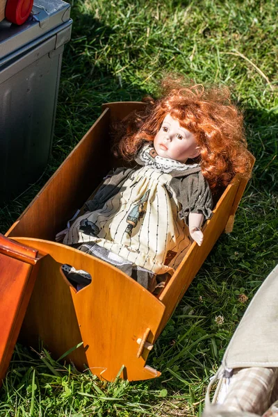 Использовала рыжую куклу в деревянной колыбели на благотворительной распродаже — стоковое фото